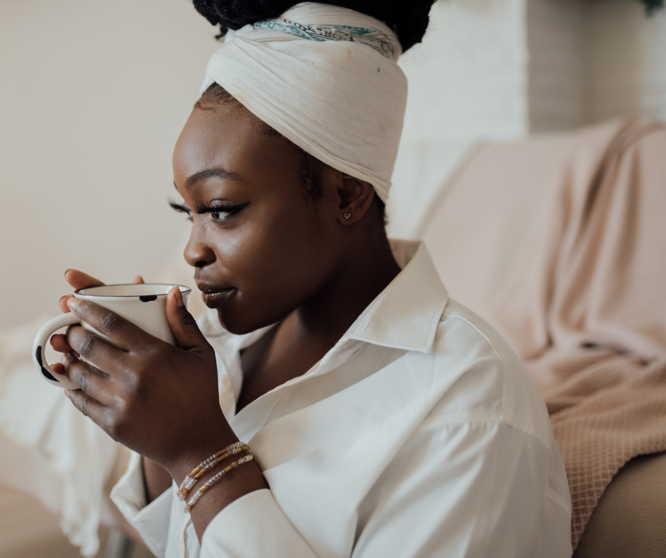 A woman holding a tea mug and about to sip